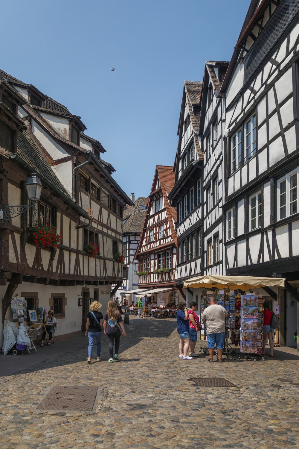 a group of people walking down a cobblestone street