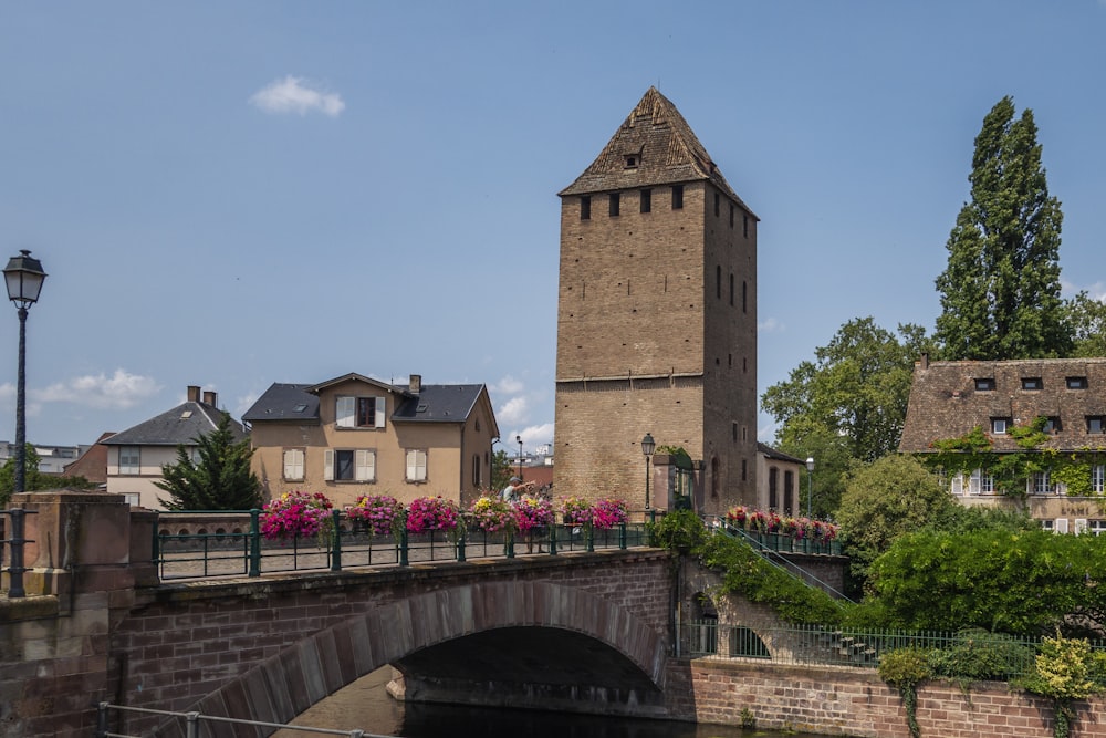 a bridge over a river with a clock tower in the background