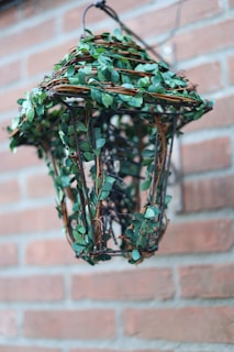 Rustic metal bird feeder with a vintage lantern design placed in a garden.