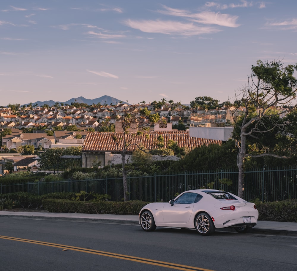 a white sports car parked on the side of the road