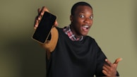 Close-up of a player excitedly checking their winning screen on a mobile device.