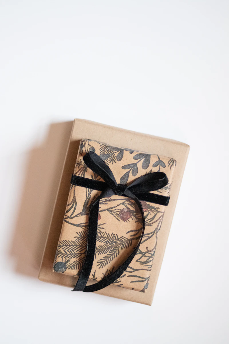 Confezione con carta a motivo botanico e fiocco nero in velluto, per ricorrenze e occasioni