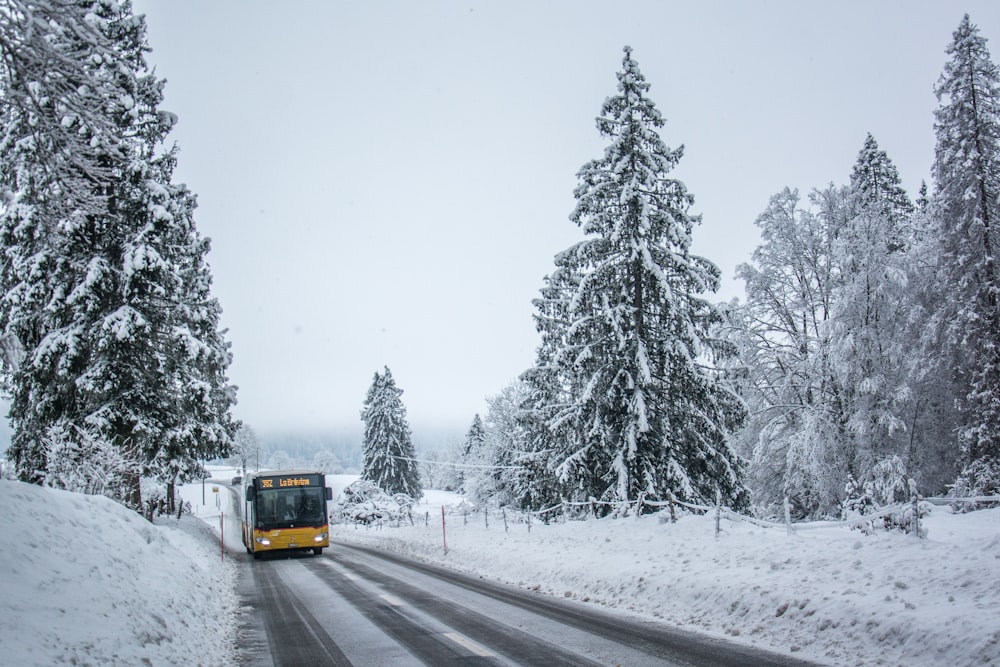 a bus driving down a snow covered road