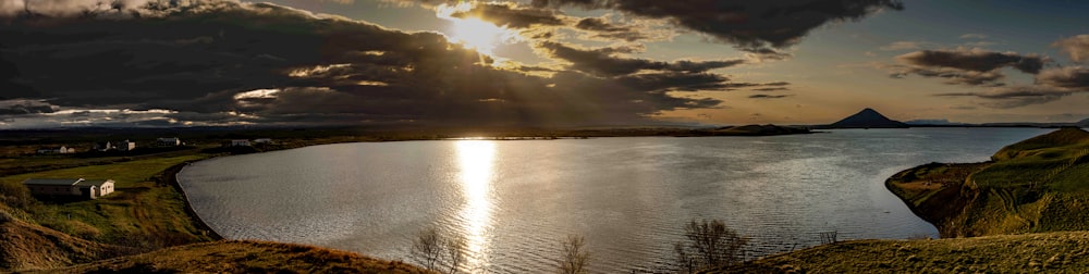 un grande specchio d'acqua seduto sotto un cielo nuvoloso