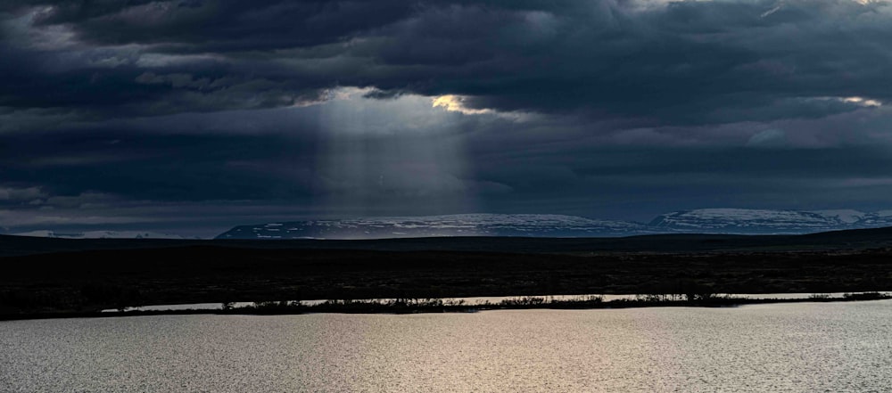 a large body of water under a cloudy sky