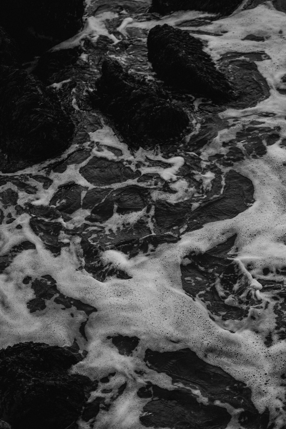 a black and white photo of water and rocks