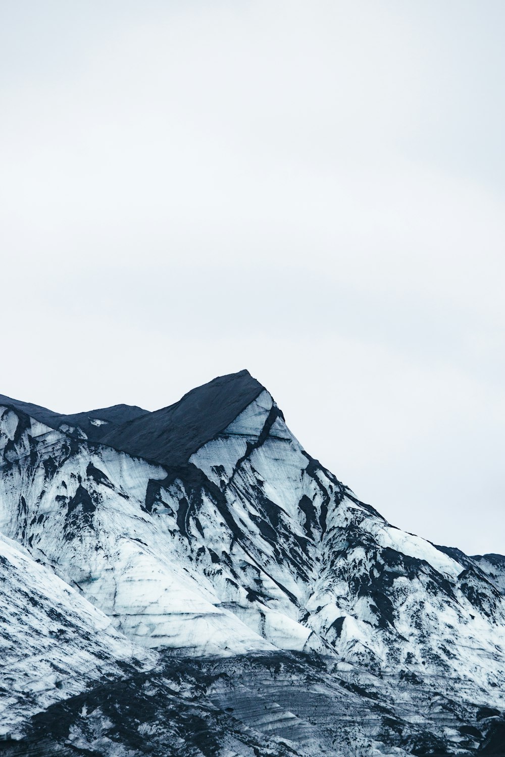 a mountain covered in snow with a sky background