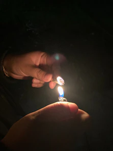 Close-up of hands passing a joint amidst laughter and smiles near a game setup.