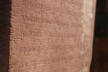 Close-up of ancient script carved into weathered stone.