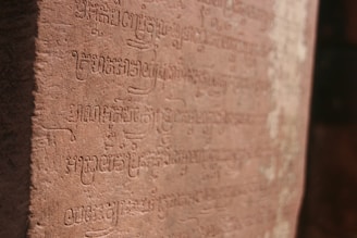 Ancient African script carved into stone, glowing softly in natural light.