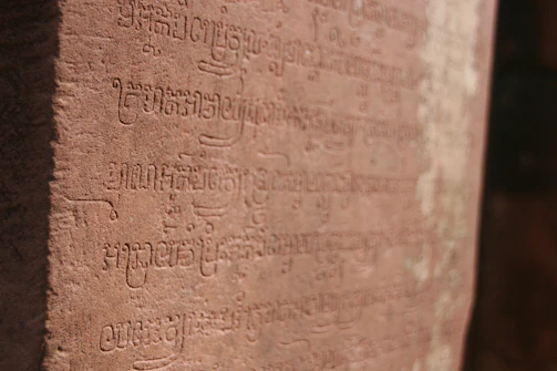 Close-up of ancient script carved into weathered stone.