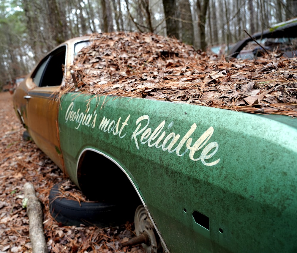 a green truck parked on top of a pile of leaves