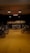 A dimly lit motorcycle garage featuring several motorcycles on a yellow floor. Various tools are displayed on the walls, and an illuminated sign reads 'MOTORIFICS'. The atmosphere is rustic and industrial.