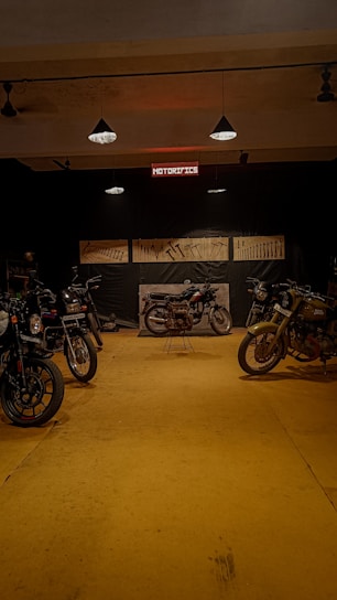 Dark industrial motorcycle workshop with custom bikes lined up under moody lighting.