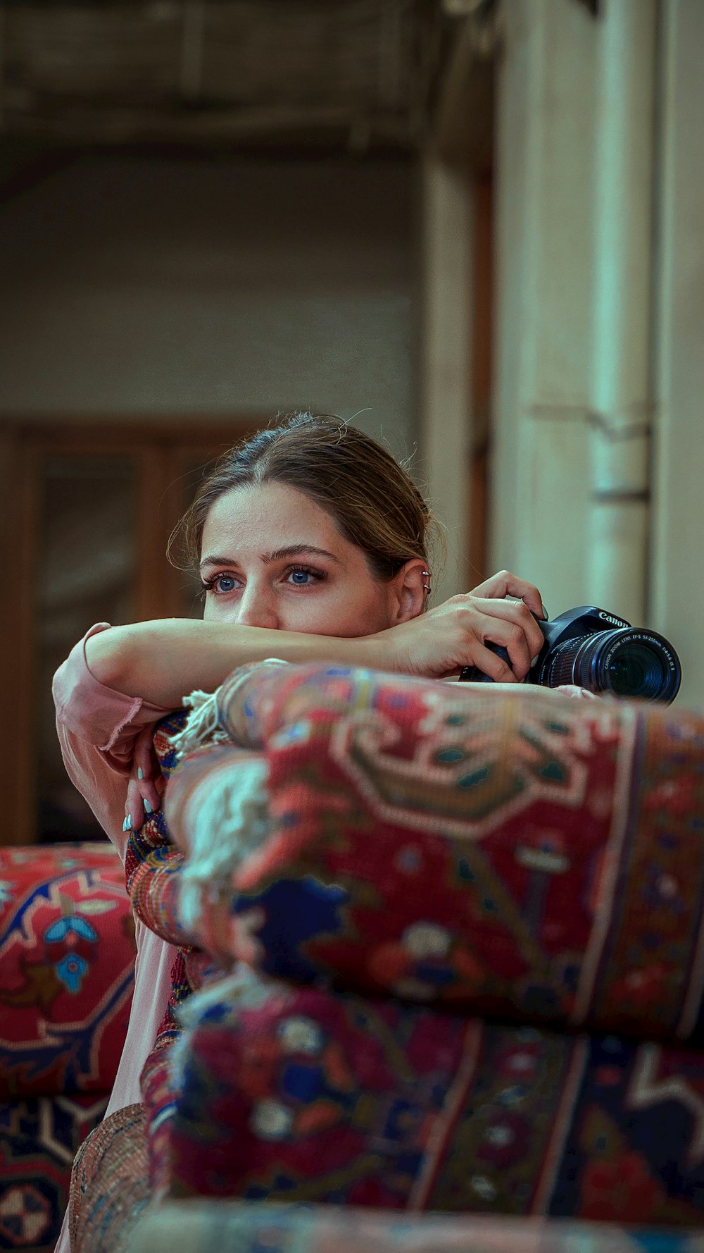 a woman sitting on a couch with a camera in her hand