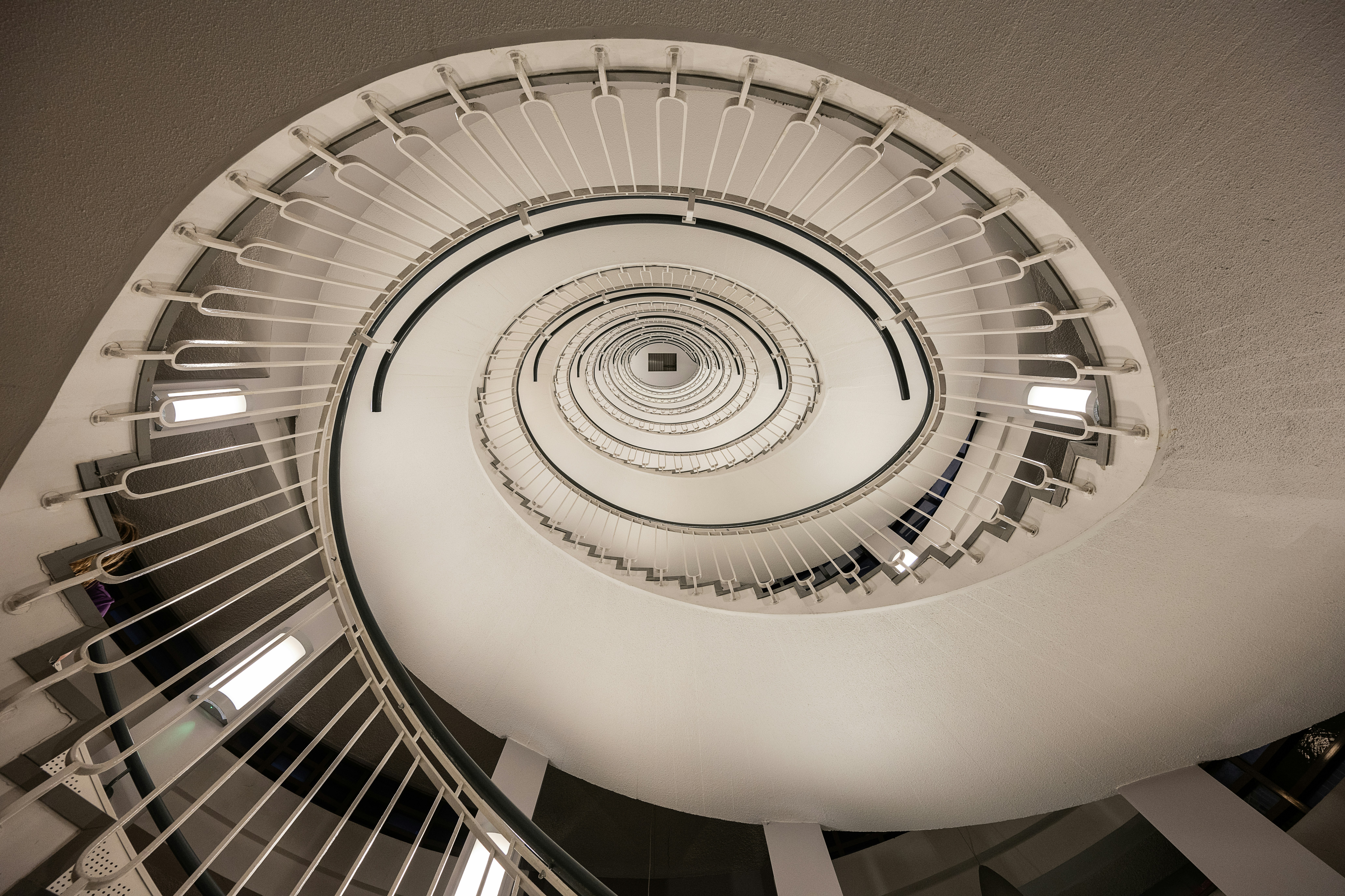 a spiral staircase in a building with white railings