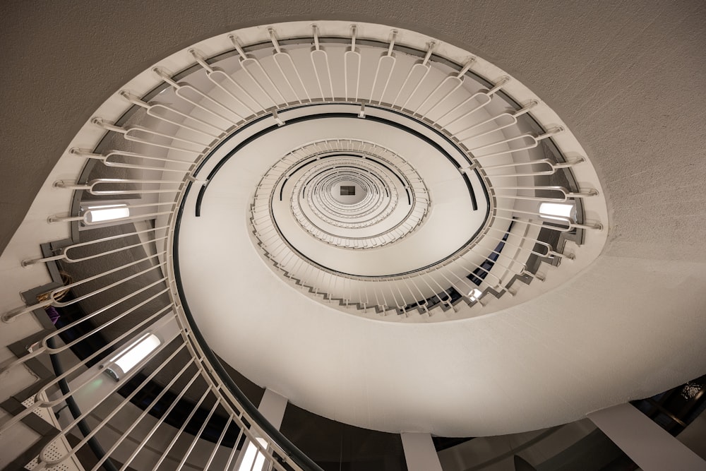 a spiral staircase in a building with white railings