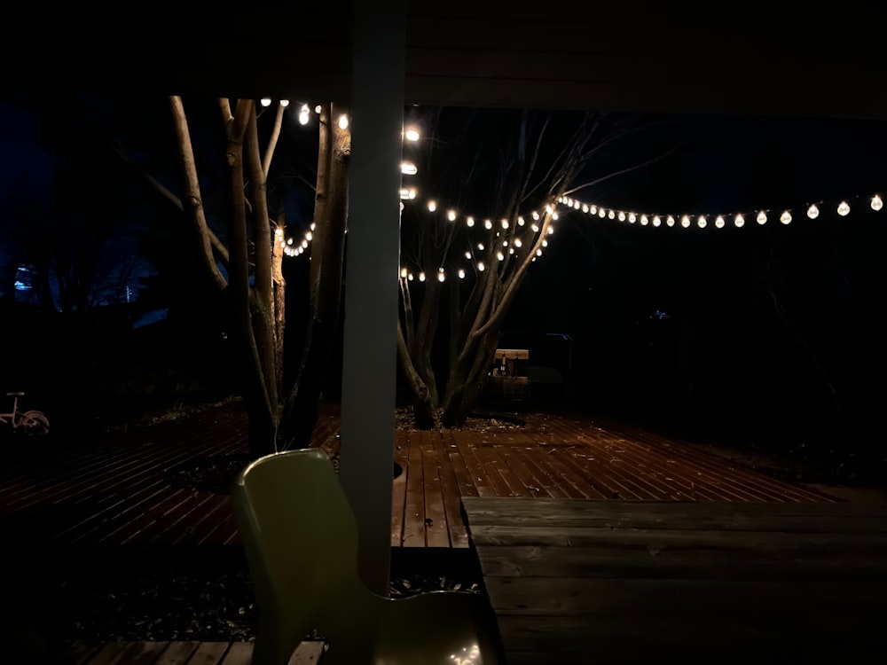 uma cadeira sentada em um deck de madeira à noite