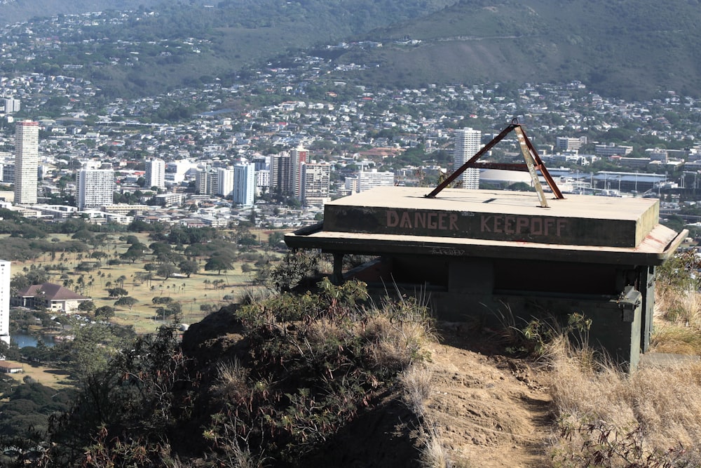 a sign on top of a hill with a city in the background