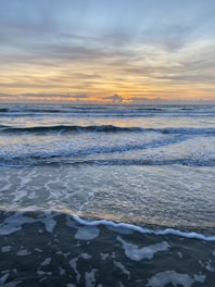 A peaceful beach scene with yoga mats laid out at sunrise.
