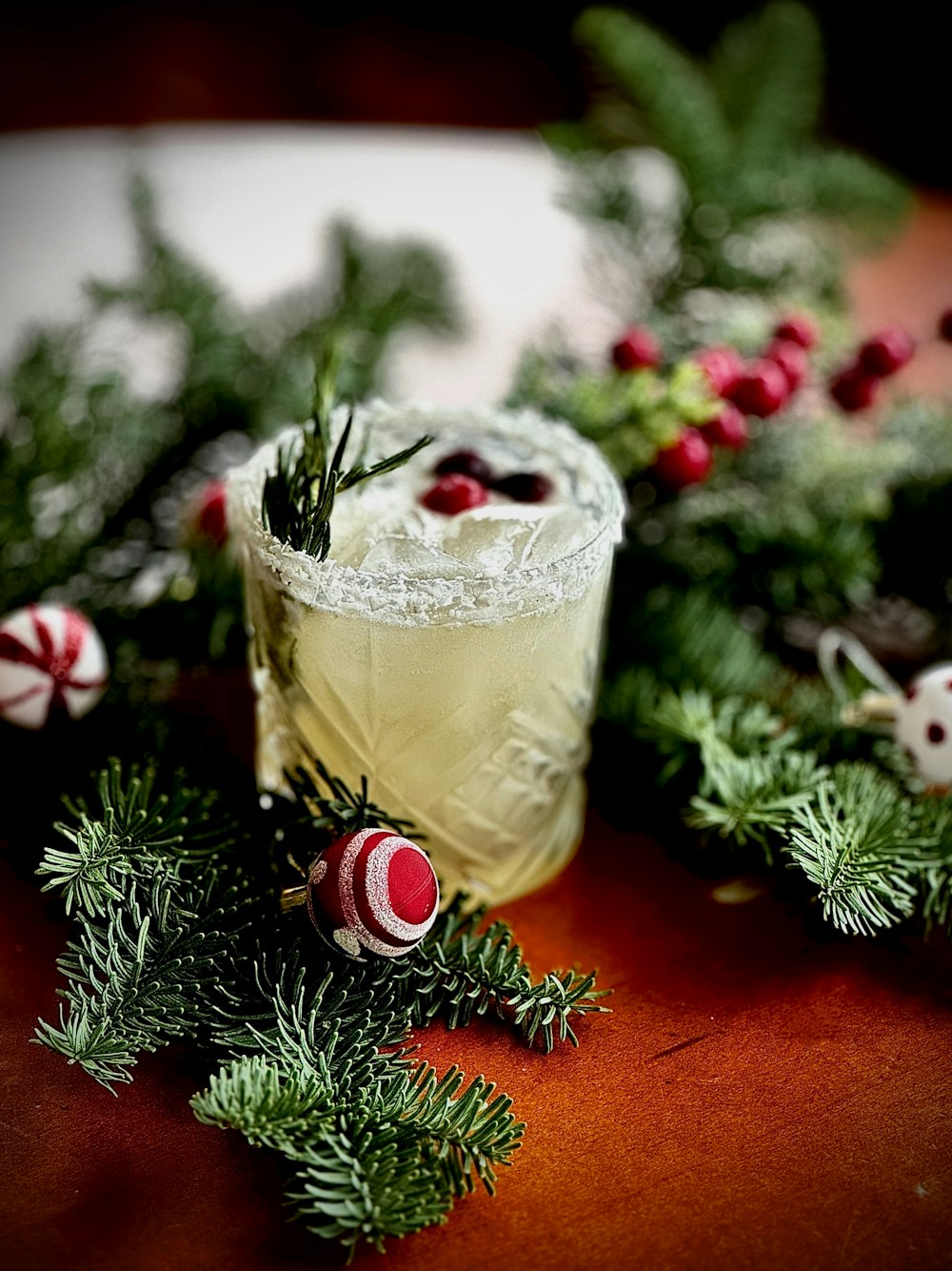 a drink with a garnish and candy canes on a table