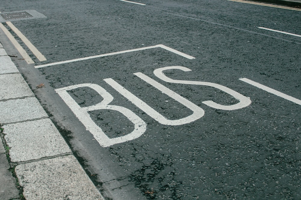 a bus stop sign painted on the side of the road