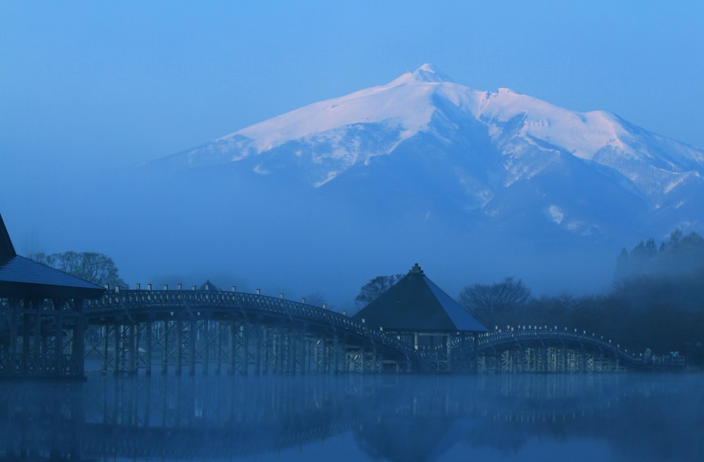 a large mountain in the distance with a bridge in the foreground