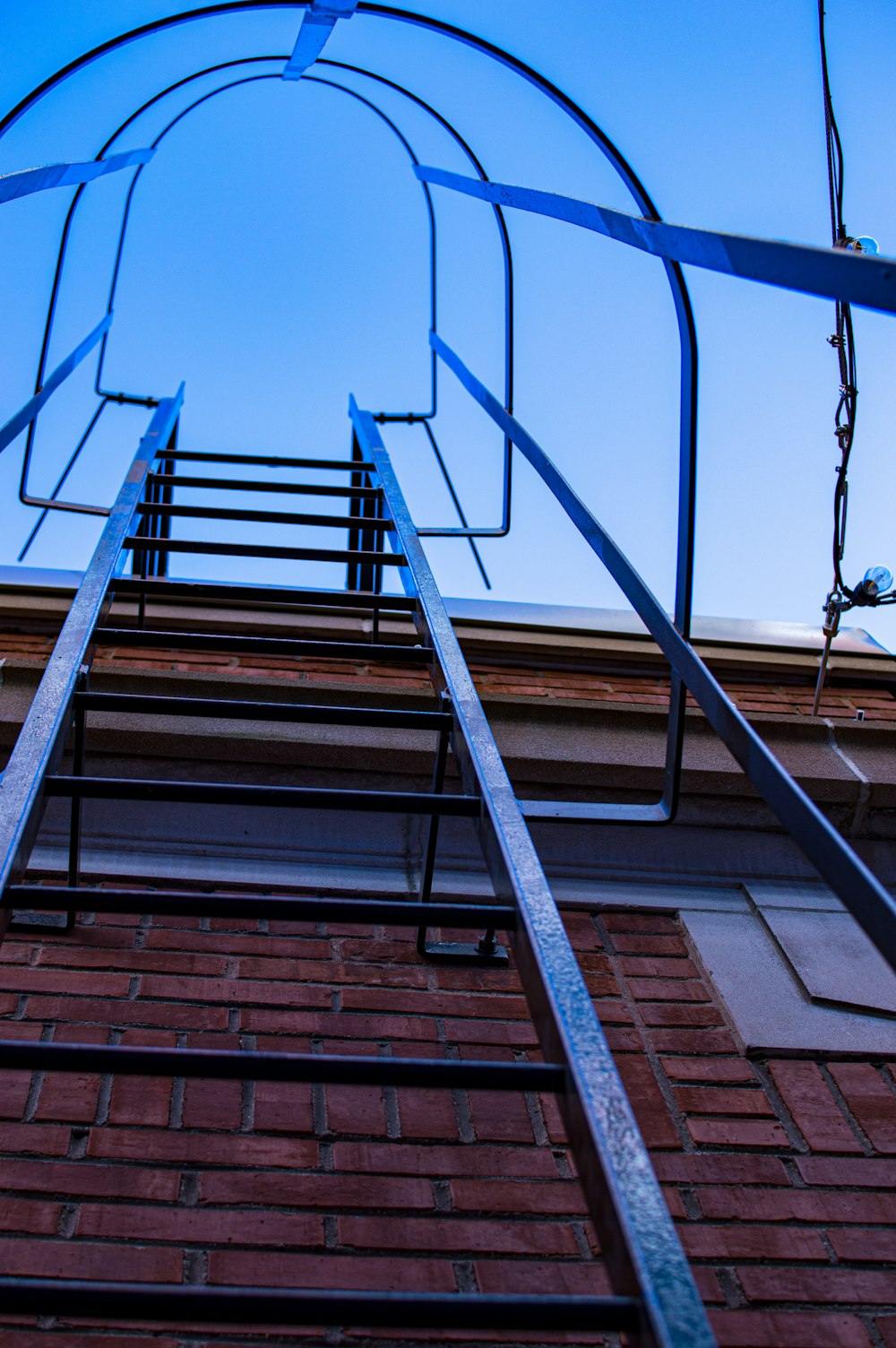 a set of metal ladders sitting on top of a brick building
