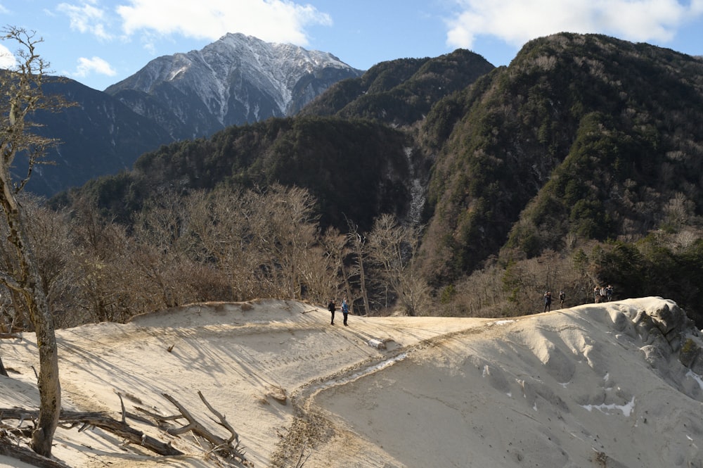 a couple of people standing on top of a snow covered slope