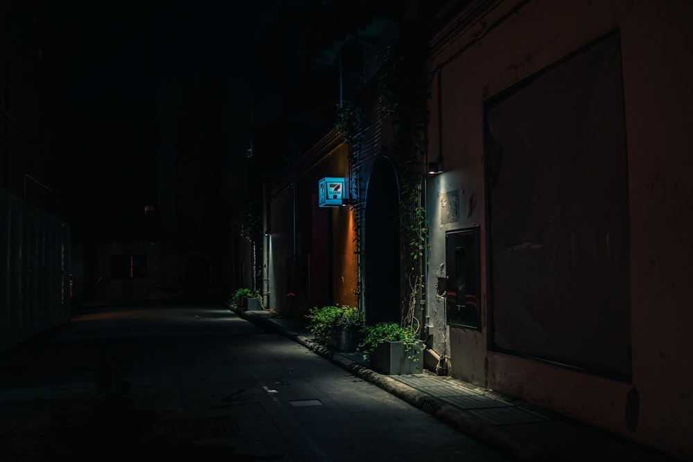 a dark alley with a street sign lit up at night