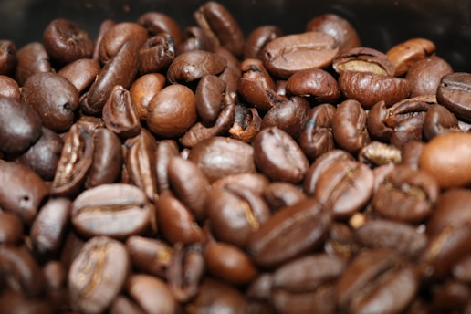 A close-up of coffee beans from different regions displayed on a wooden table.