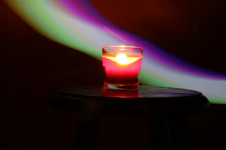 Close-up of a handcrafted wooden candle holder with swirling epoxy resin in green and violet hues.
