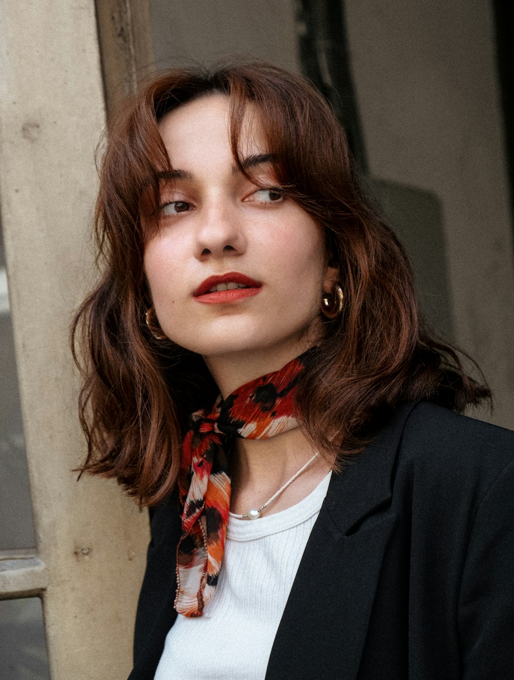 a woman wearing a black jacket and a red scarf