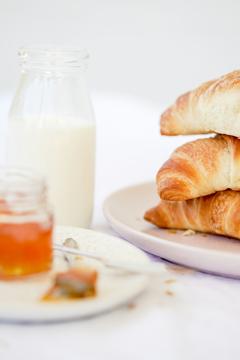 a plate of croissants and a glass of milk
