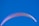 A vibrant paragliding wing is seen against a clear, cloudless sky. The wing is primarily white with hints of pink and purple hues along its edges.