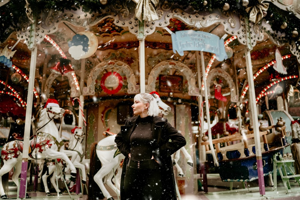 a woman standing in front of a merry go round