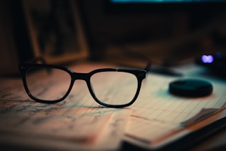 a pair of glasses sitting on top of a notebook