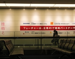 a man standing in front of a sign in an airport
