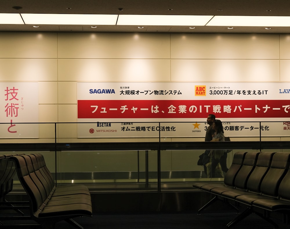 a man standing in front of a sign in an airport