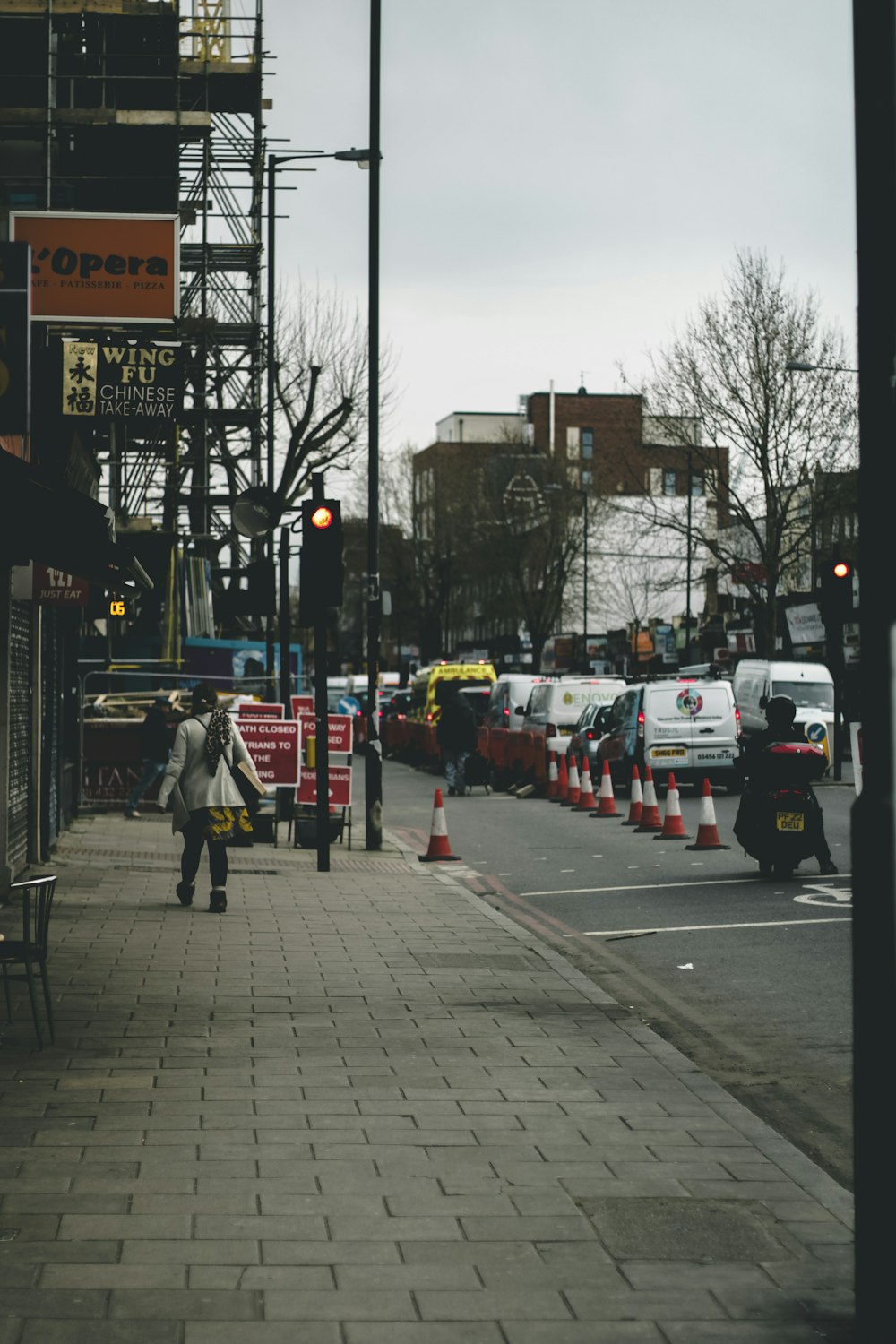 a man walking down a sidewalk next to a traffic light