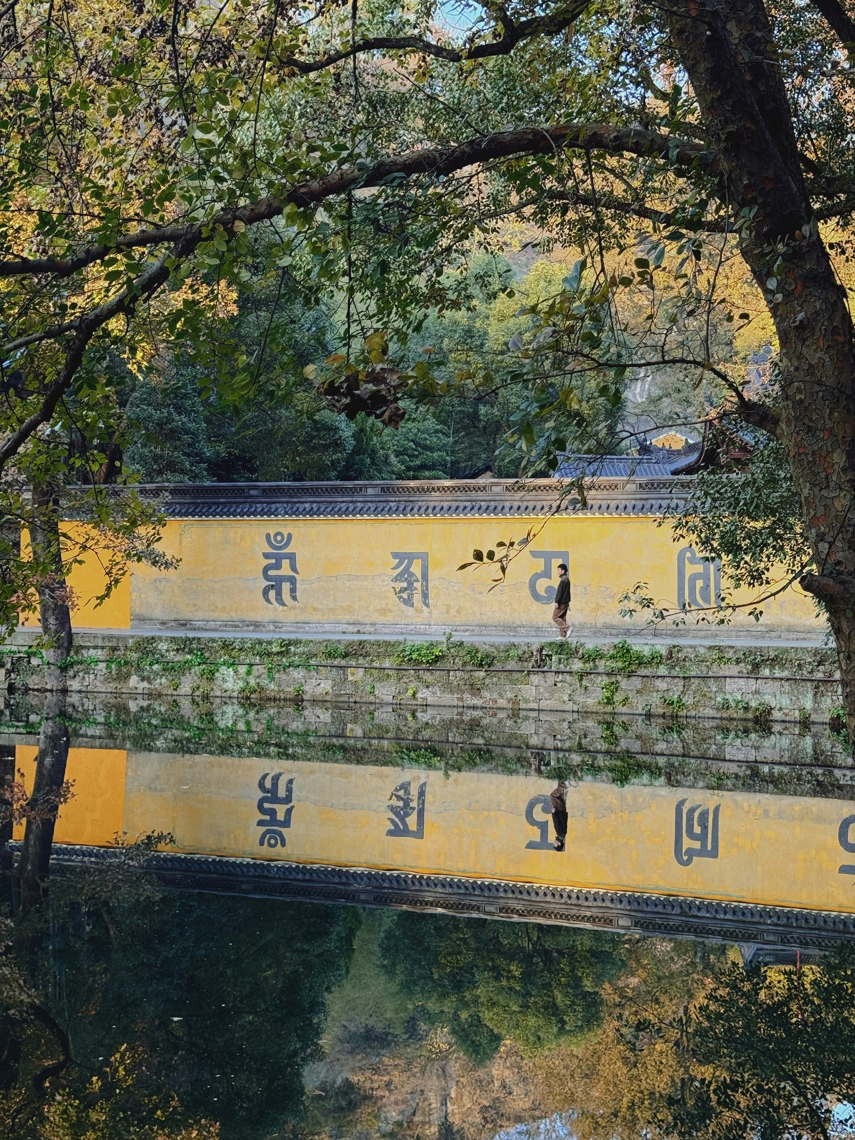 a yellow bridge over a body of water surrounded by trees