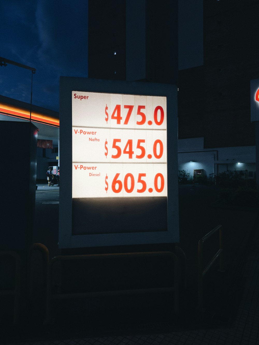 a sign advertising a gas station at night