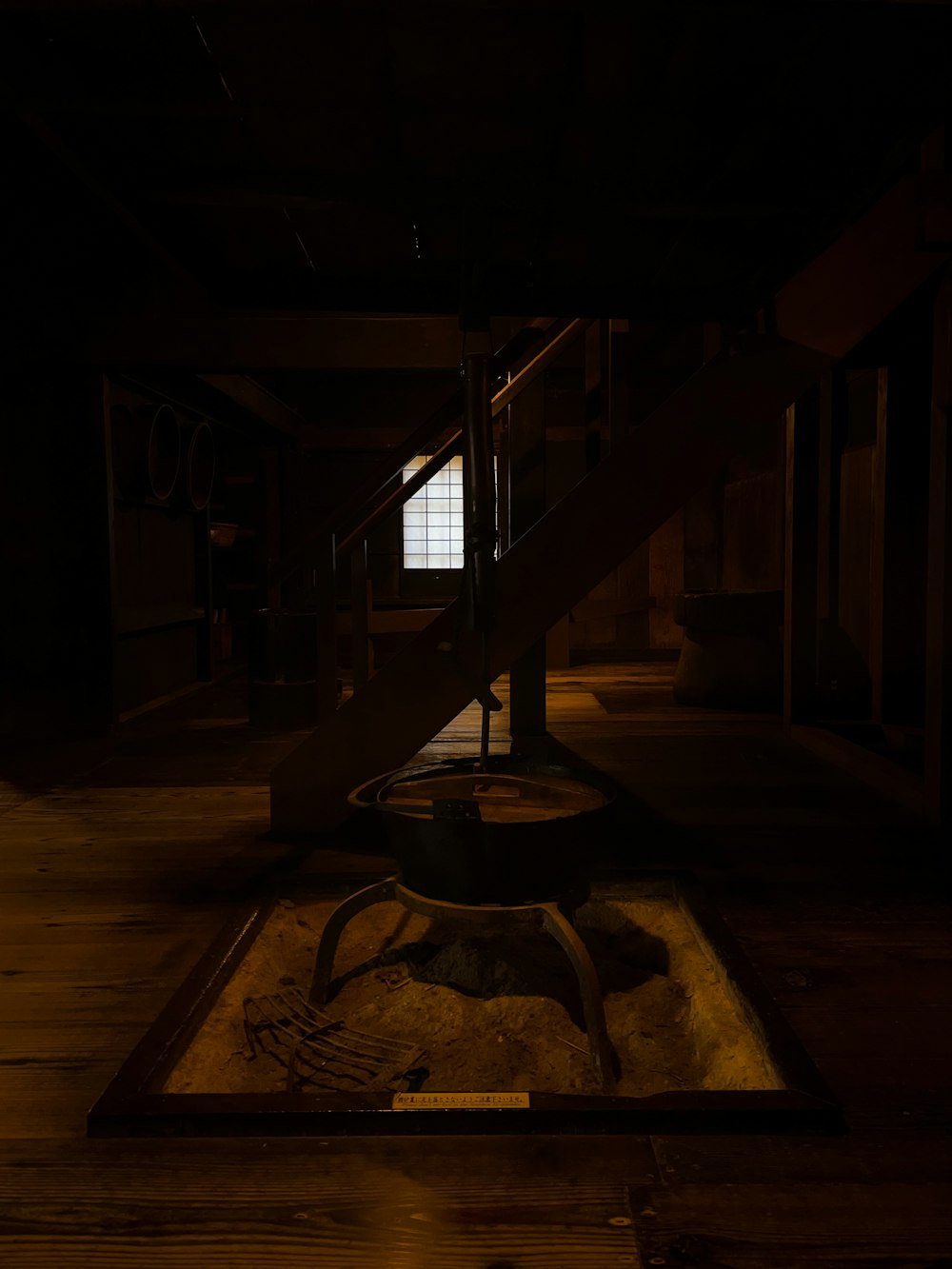 a dark room with stairs and a window