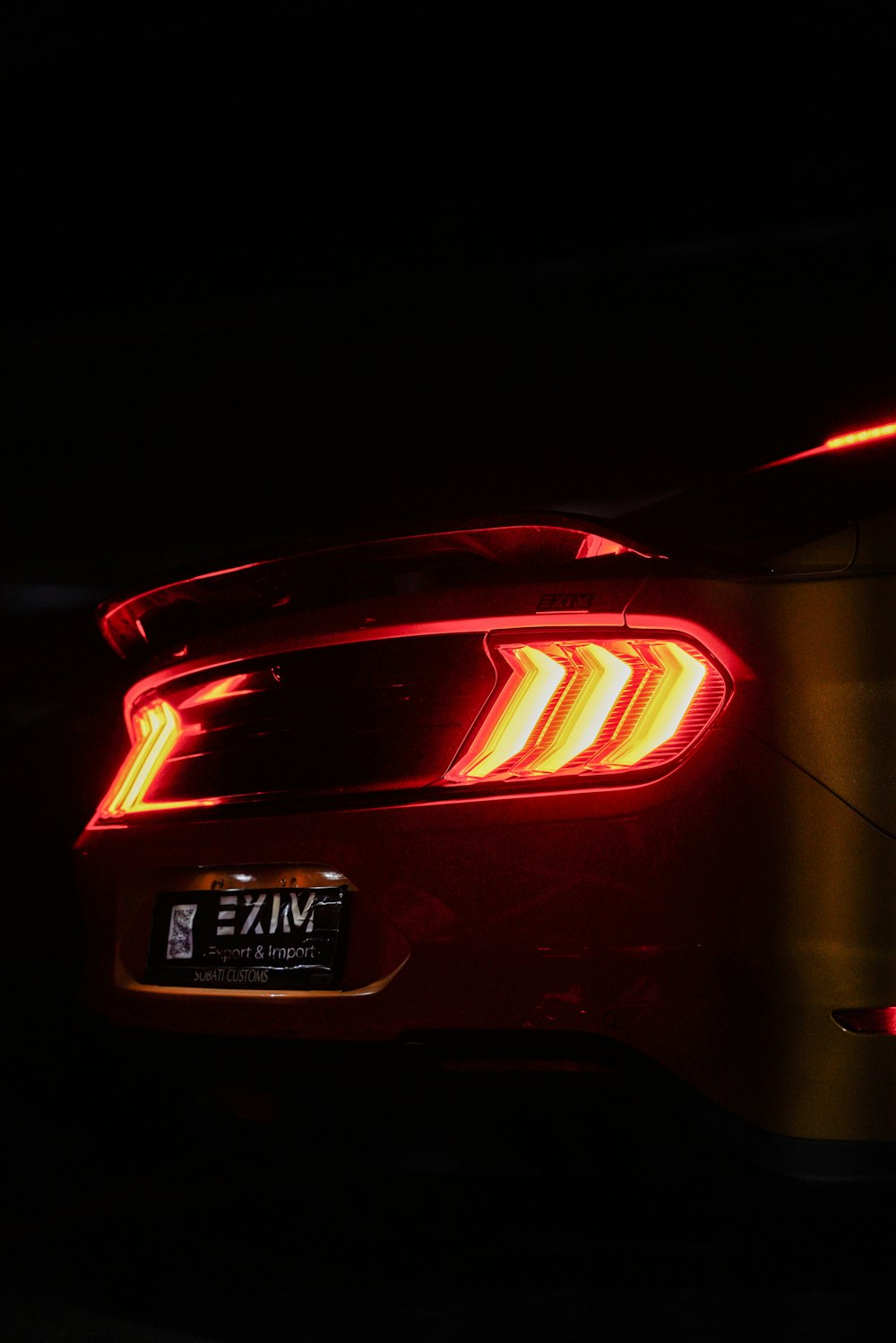 the tail lights of a car in the dark