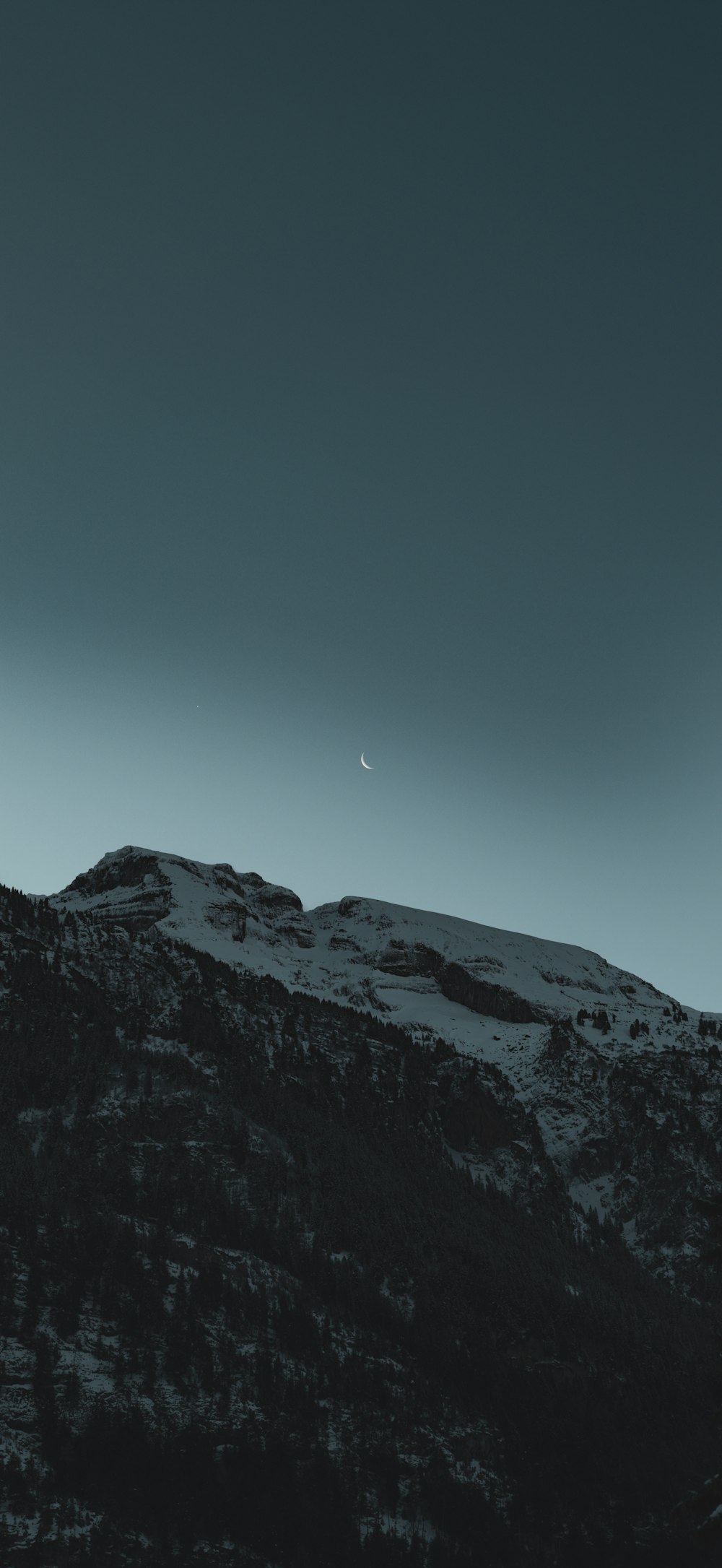 a mountain covered in snow under a dark sky