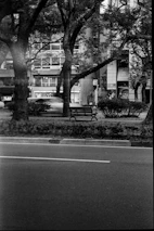 Black and white photo of an empty urban bench symbolizing solitude.