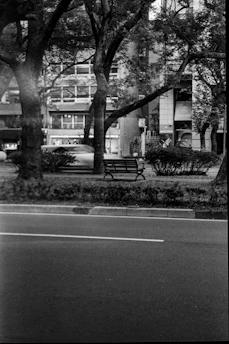 Black and white photo of an empty urban bench symbolizing solitude.