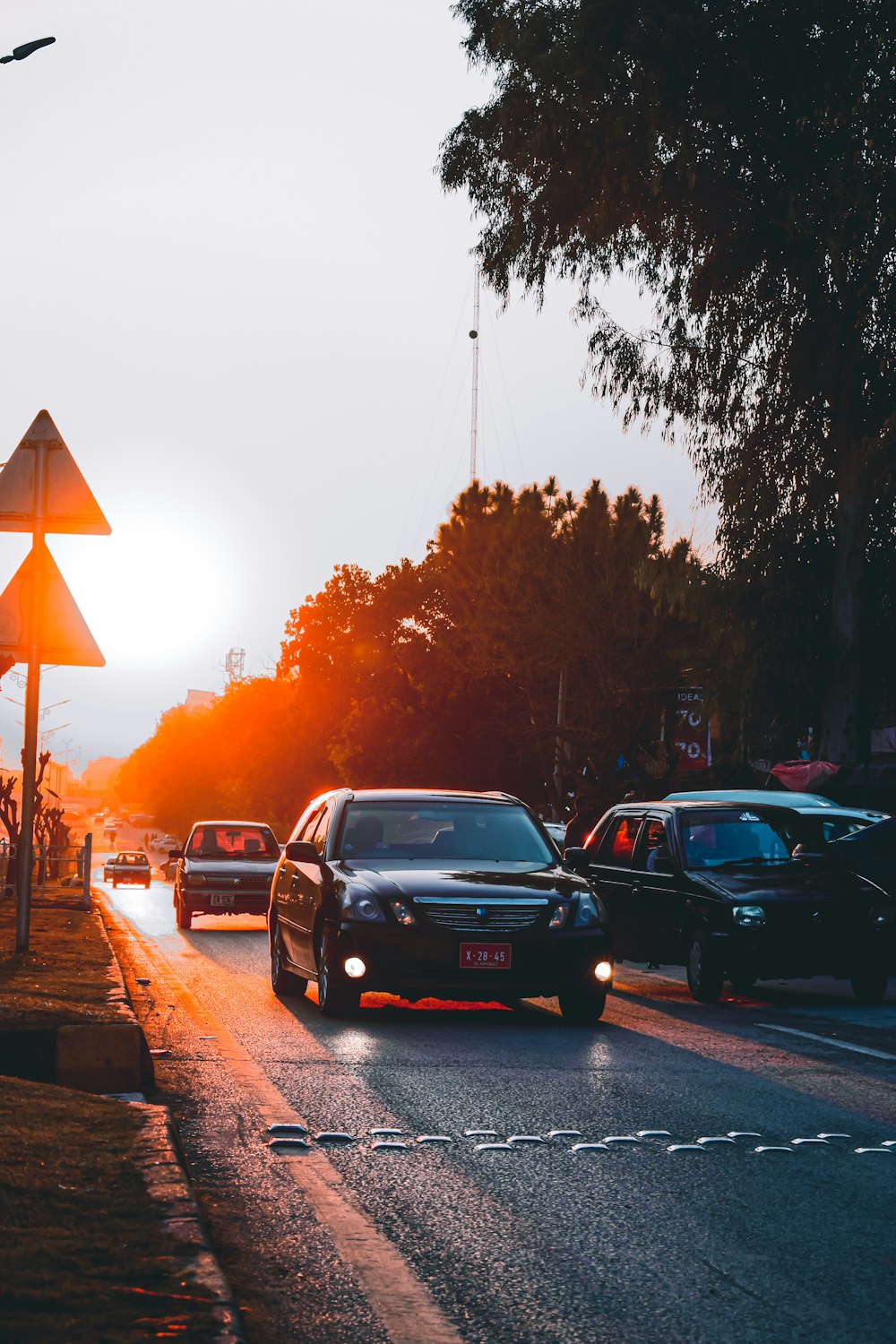 cars driving down a street at sunset
