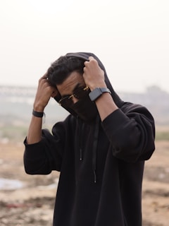Close-up of a person adjusting the hood of their soft, grey hoodie on a chilly day.