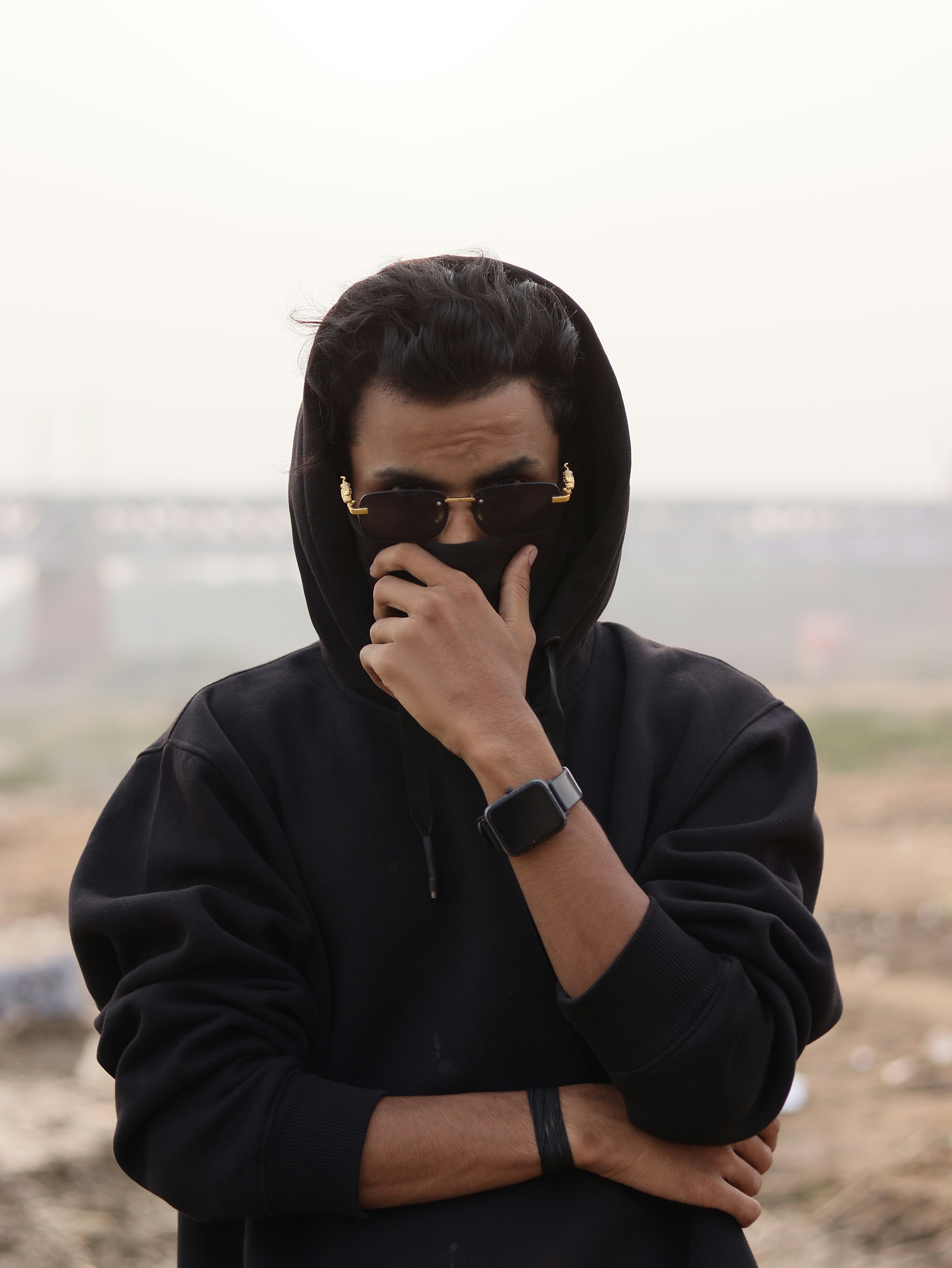 Seorang pria mengenakan hoodie hitam dan kacamata hitam
